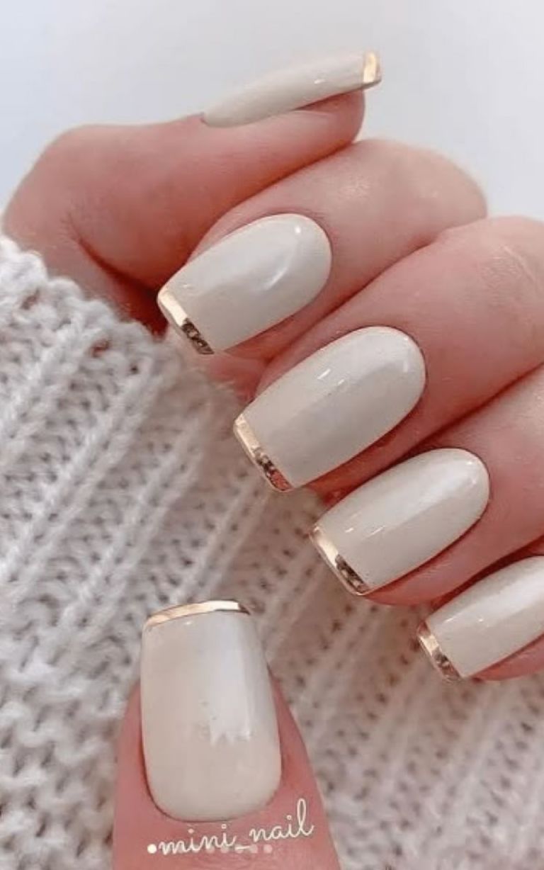 Diseño de uñas blancas con manicura francesa dorada