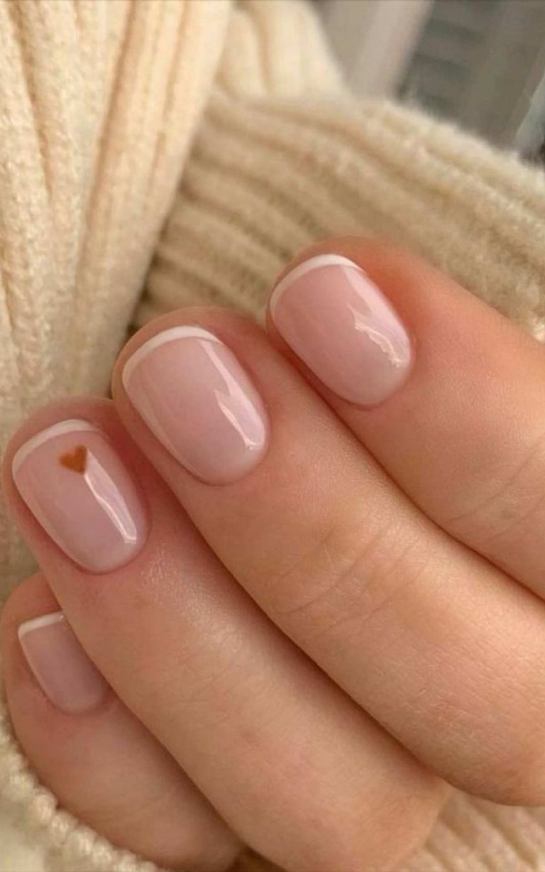 Manicura estilo baby french en blanco con mini corazón rojo como acento